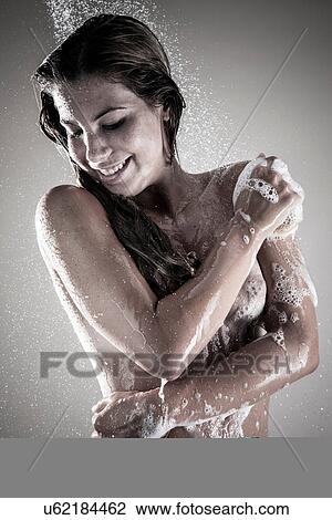 Young woman showering, studio shot View Large Photo Image Stock Image - Young woman showering, studio shot. Fotosearch