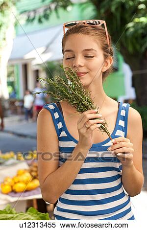Young woman smelling herbs at market View Large Photo Image Stock Photography - Young woman smelling herbs at market. Fotosearch