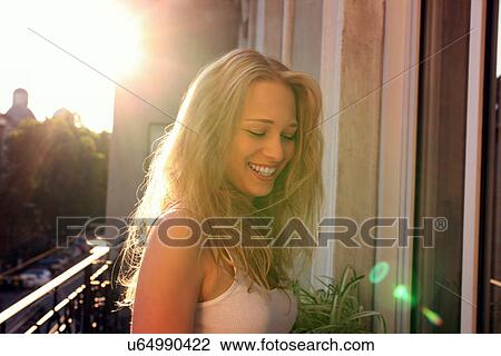 Young woman standing on city apartment balcony View Large Photo Image Stock Image - Young woman standing on city apartment balcony. Fotosearch