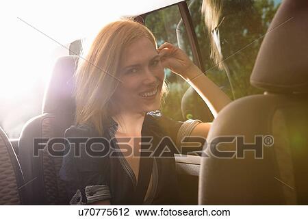 Young woman travelling in back seat of car View Large Photo Image Stock Image - Young woman travelling in back seat of car. Fotosearch