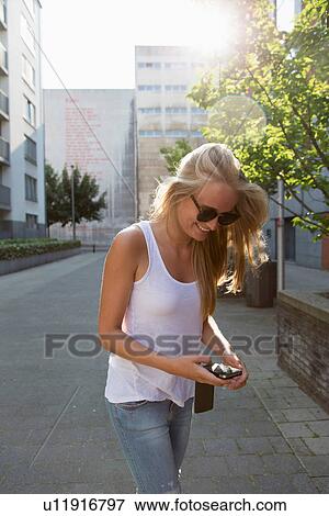Young woman using cellular phone View Large Photo Image Stock Photo - Young woman using cellular phone. Fotosearch