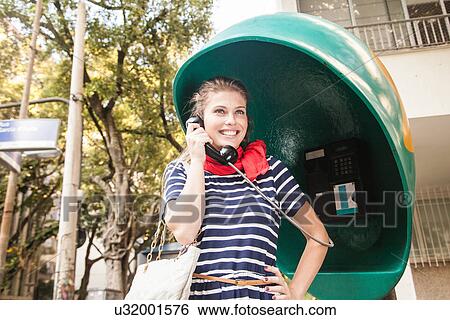 Young woman using pay telephone View Large Photo Image Stock Photograph - Young woman using pay telephone. Fotosearch