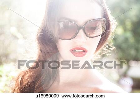 Stock Photo - Young woman wearing sunglasses. Fotosearch