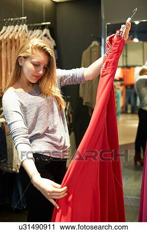 Young woman with red dress in fitting room View Large Photo Image Stock Image - Young woman with red dress in fitting room. Fotosearch