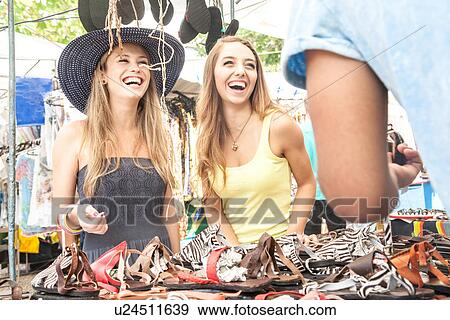 Young women looking at sandals in market View Large Photo Image Stock Photo - Young women looking at sandals in market. Fotosearch