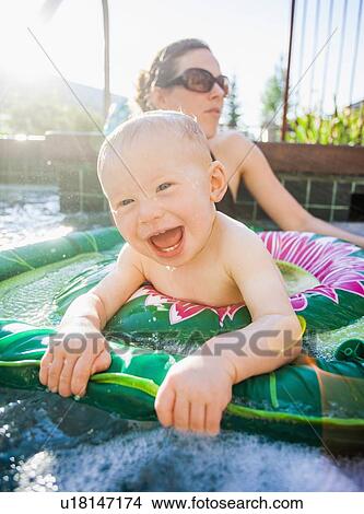 Picture - Baby boy (18-23 months) playing in swimming pool with his mother. Fotosearch