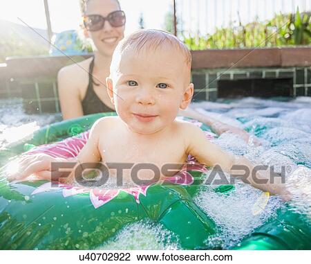 Baby boy (18-23 months) playing in swimming pool with his mother View Large Photo Image Stock Image - Baby boy (18-23 months) playing in swimming pool with his mother. Fotosearch