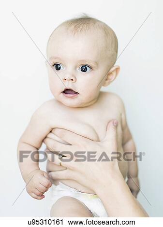 Baby boy (6-11 months) held by adult View Large Photo Image Stock Image - Baby boy (6-11 months) held by adult. Fotosearch