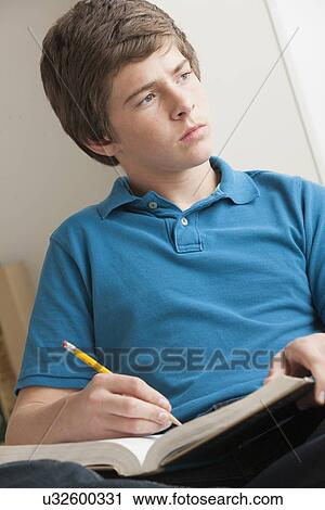 Stock Image - Boy (14-15) studying. Fotosearch