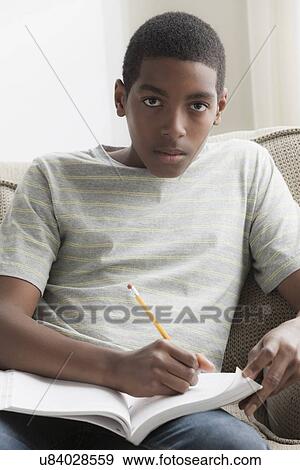 Stock Photo - Boy (14-15) studying. Fotosearch