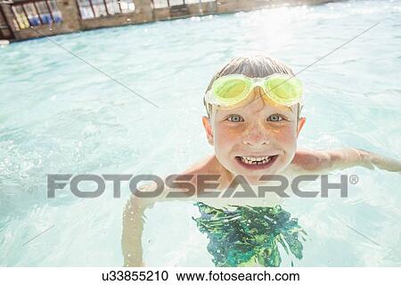 Stock Image - Boy (4-5) posing in swimming pool. Fotosearch