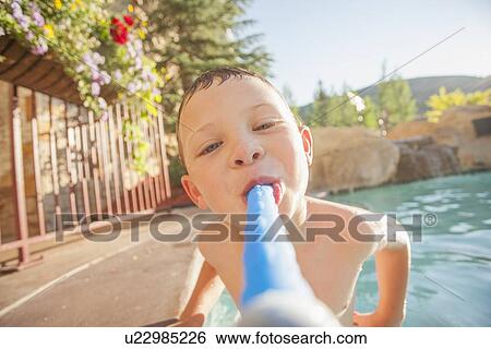 Stock Photograph - Boy (4-5) posing in swimming pool. Fotosearch