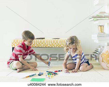 Boy and girl (4-5, 6-7) sitting on floor and drawing View Large Photo Image Picture - Boy and girl (4-5, 6-7) sitting on floor and drawing . Fotosearch