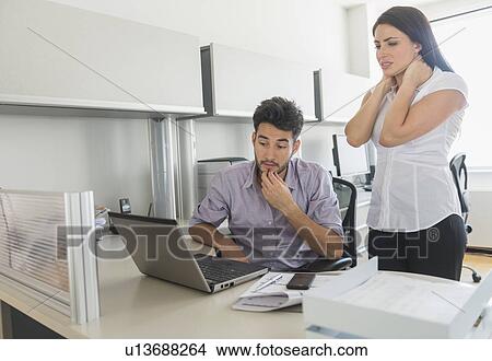 Picture - Business man and woman at work in office. Fotosearch