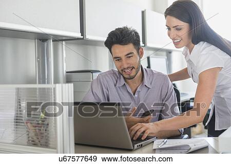 Stock Photo - Business man and woman at work in office. Fotosearch
