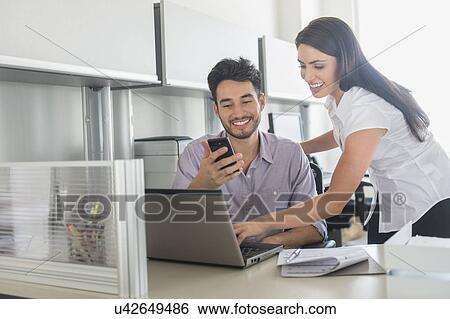 Stock Photograph - Business man and woman at work in office. Fotosearch