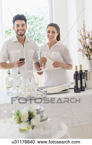 Business owners preparing dining table View Large Photo Image Stock Image - Business owners preparing dining table. Fotosearch