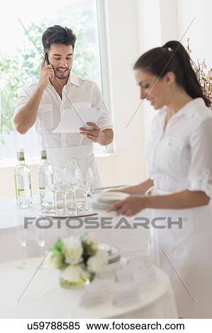 Business owners preparing dining table View Large Photo Image Stock Photography - Business owners preparing dining table. Fotosearch