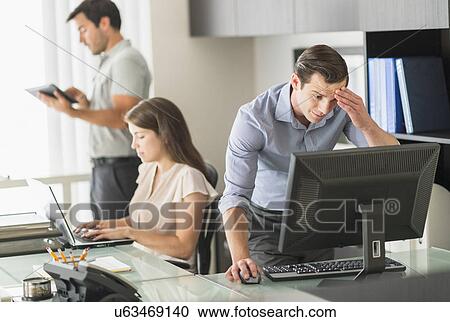 Stock Image - Business people working in office. Fotosearch