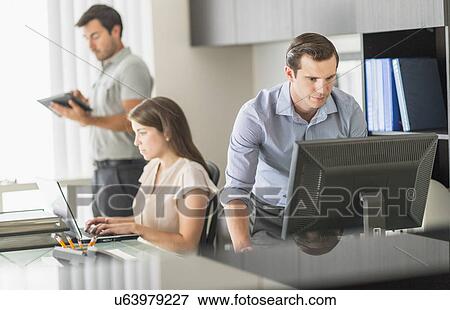 Stock Photo - Business people working in office. Fotosearch