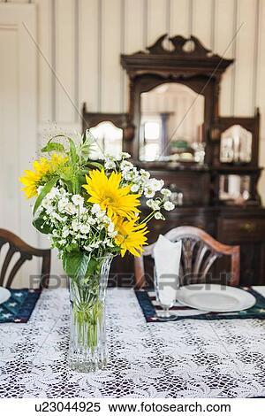Stock Photography - Close-up of flowers in vase on table in dining room. Fotosearch