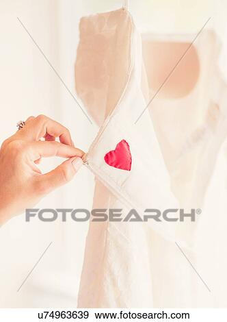 Stock Photo - Close up of woman's hand holding wedding dress. Fotosearch