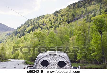 Stock Image - Coin operated binocular facing green hill. Fotosearch
