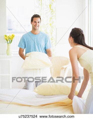 Picture - Couple making bed. Fotosearch