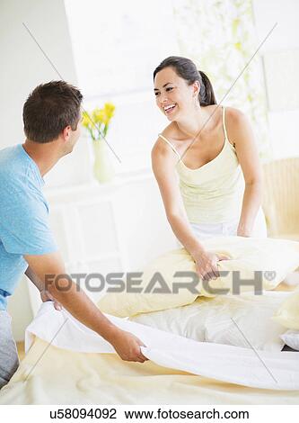 Couple making bed View Large Photo Image Stock Image - Couple making bed. Fotosearch