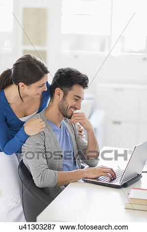Stock Photo - Couple using laptop at home. Fotosearch