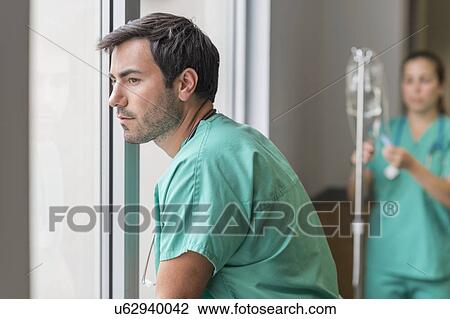 Doctor looking out window View Large Photo Image Stock Image - Doctor looking out window. Fotosearch