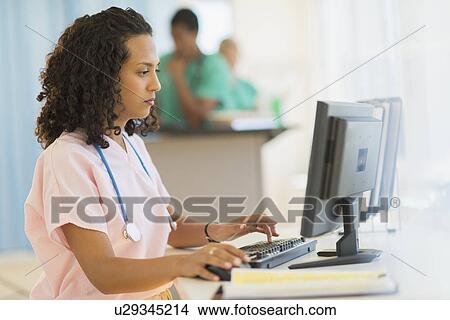 Doctor working at desks in hospital View Large Photo Image Picture - Doctor working at desks in hospital. Fotosearch