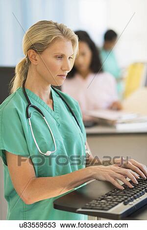 Doctor working at desks in hospital View Large Photo Image Stock Image - Doctor working at desks in hospital. Fotosearch