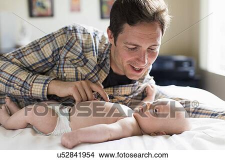 Picture - Father playing with baby boy (2-5 months). Fotosearch