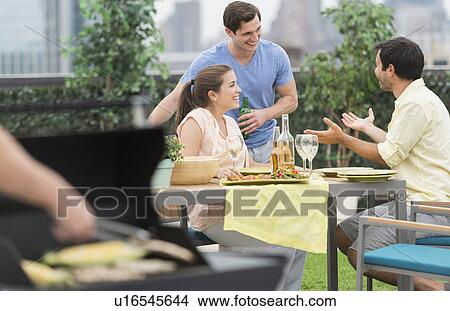Picture - Friends enjoying barbecue in garden. Fotosearch