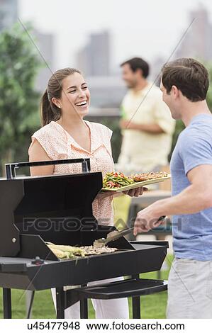Friends enjoying barbecue in garden View Large Photo Image Stock Photo - Friends enjoying barbecue in garden. Fotosearch