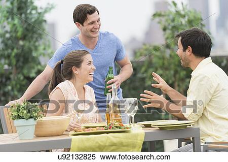 Stock Photography - Friends enjoying barbecue in garden. Fotosearch