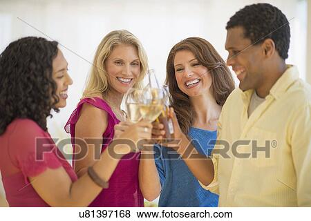 Stock Photo - Friends making toast at party. Fotosearch