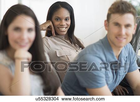 Friends sitting on sofa View Large Photo Image Picture - Friends sitting on sofa. Fotosearch