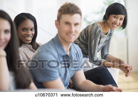 Friends sitting on sofa View Large Photo Image Stock Image - Friends sitting on sofa. Fotosearch