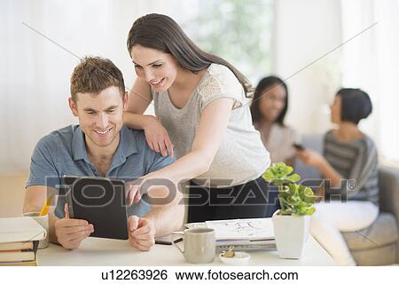 Stock Photograph - Friends using digital tablet. Fotosearch