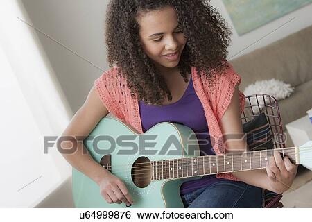 Girl (12-13) playing guitar View Large Photo Image Stock Photograph - Girl (12-13) playing guitar. Fotosearch