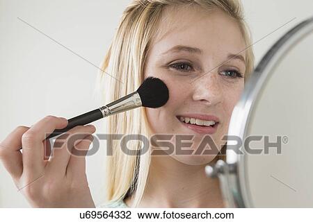 Girl (14-15) applying make up View Large Photo Image Stock Image - Girl (14-15) applying make up. Fotosearch