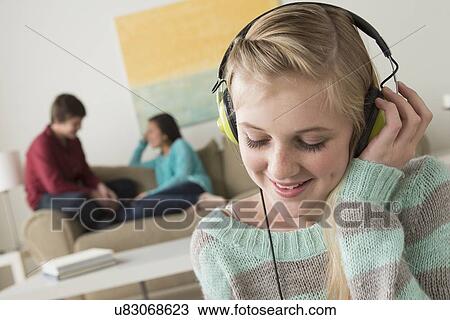 Girl (14-15) listening to music wearing headphones View Large Photo Image Stock Image - Girl (14-15) listening to music wearing headphones. Fotosearch