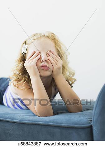 Girl (4-5) lying on bench rubbing her eyes View Large Photo Image Stock Photo - Girl (4-5) lying on bench rubbing her eyes. Fotosearch