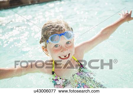 Stock Photo - Girl (4-5) playing in swimming pool. Fotosearch