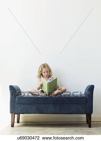 Girl (4-5) sitting on bench and reading book View Large Photo Image Stock Image - Girl (4-5) sitting on bench and reading book. Fotosearch