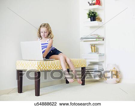 Girl (4-5) sitting on bench using laptop View Large Photo Image Stock Image - Girl (4-5) sitting on bench using laptop. Fotosearch