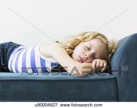 Stock Photo - Girl (4-5) sleeping on bench indoors. Fotosearch