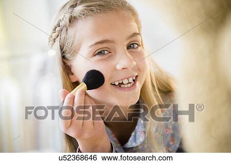 Stock Photograph - Girl (8-9) applying make-up. Fotosearch